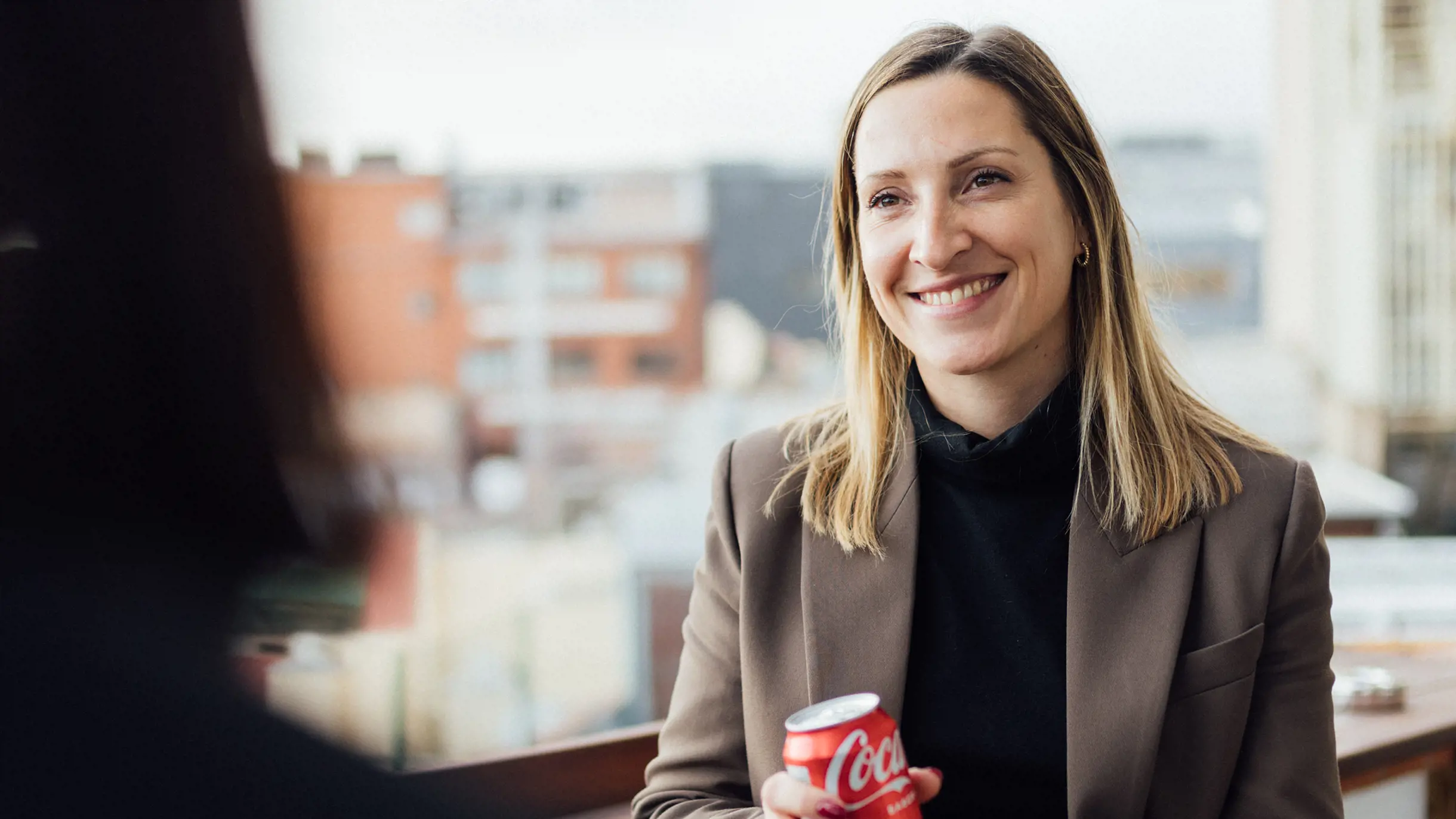 Woman smiling while having a soft drink