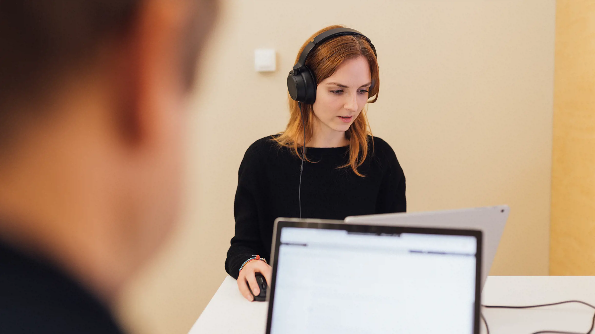 Woman with headphones concentrated working on a screen